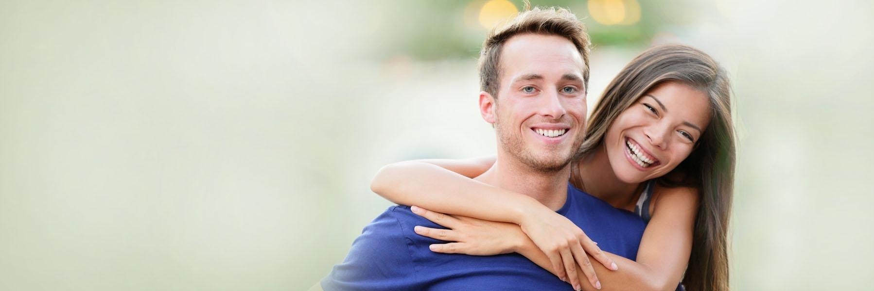 Young couple laughing & hugging outside near Gainesville GA