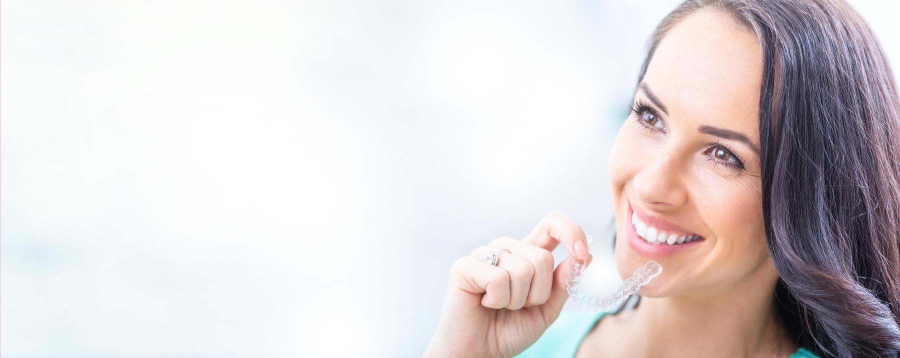 Close up of woman putting on Invisalign in Flowery Branch GA